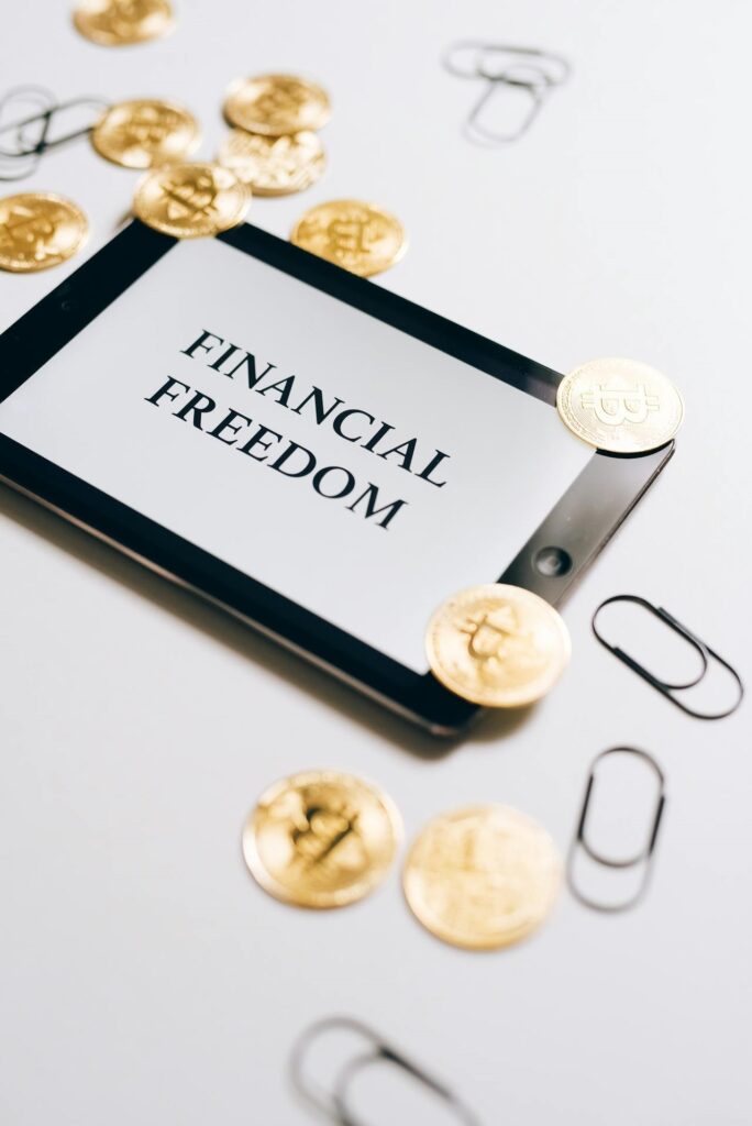 iPad with coins and the words financial freedom, a potential result of building wealth with assets.