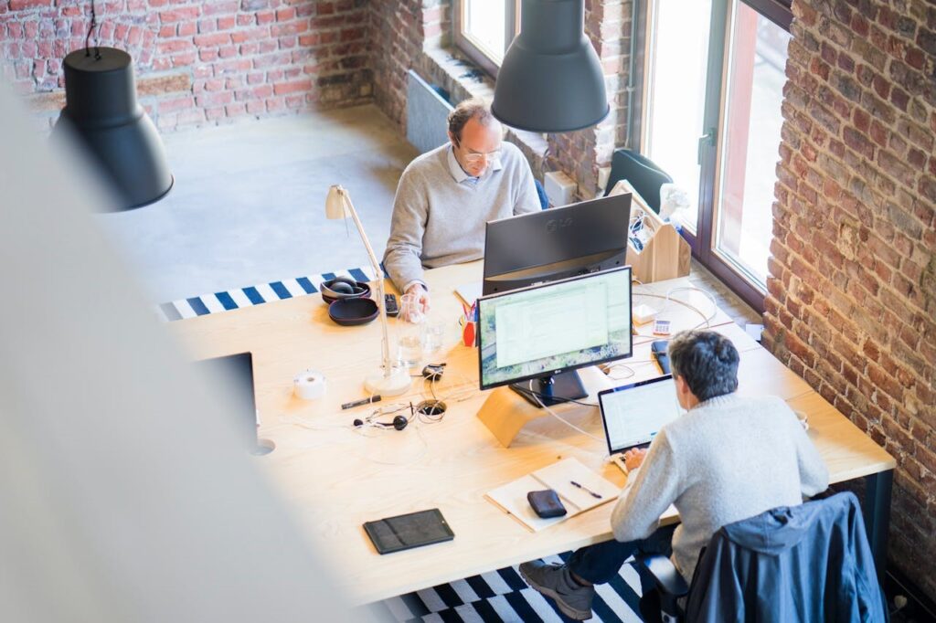 Two workers at a small business on their computers.